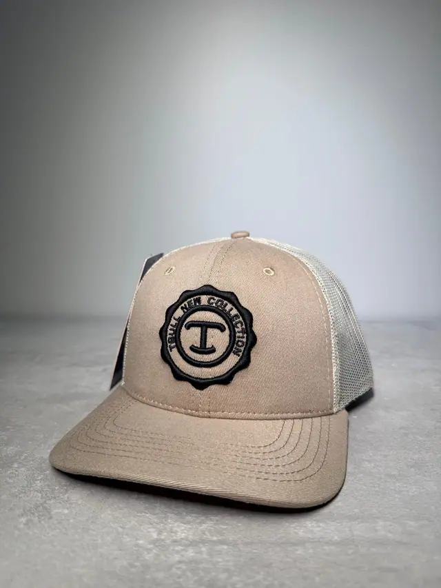Boné trucker caqui com tela bege e selo circular preto, modelo Terras Nobres, em foto de estúdio.
