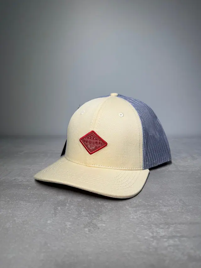 Boné TBull trucker Tropa de Campo, creme com tela cinza e patch losango, em foto de estúdio.
