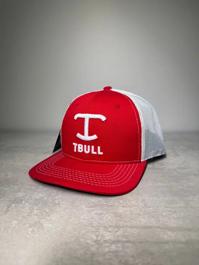 Boné trucker vermelho com tela branca, monograma T em bordado alto e a palavra TBULL bordada em branco.