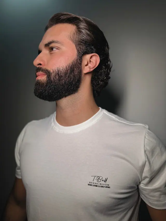 Camiseta Signature em três quartos: a assinatura T·Bull e o lettering fino do peito vistos de perto.