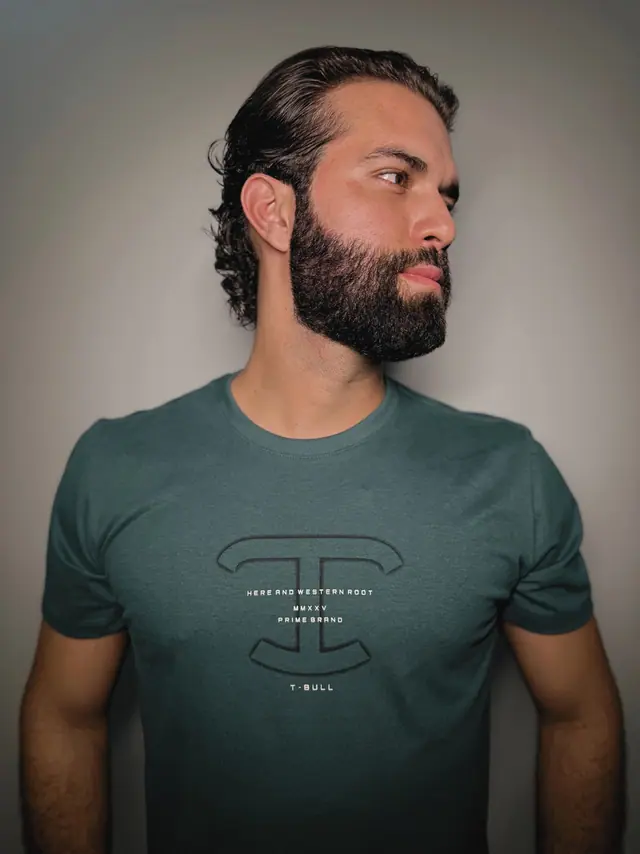 Camiseta Desert em três quartos: contorno do monograma e o micro-lettering da marca vistos de perto.